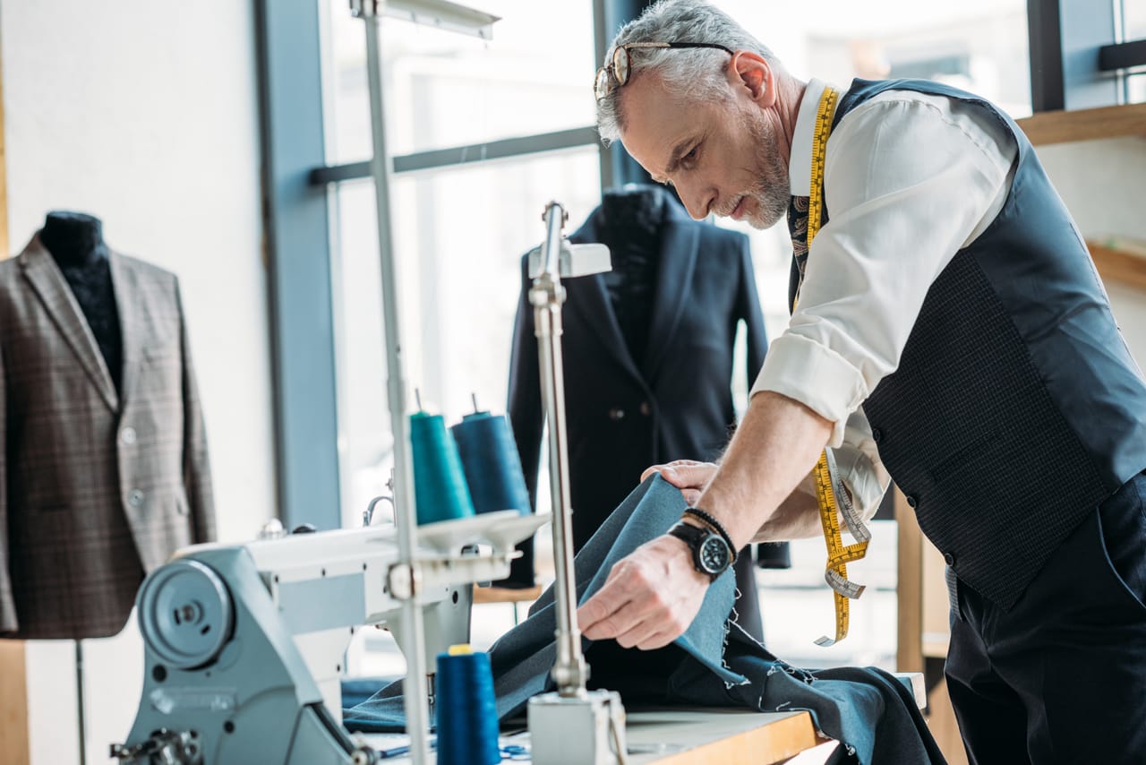 Related image handsome tailor looking cloth sewing workshop